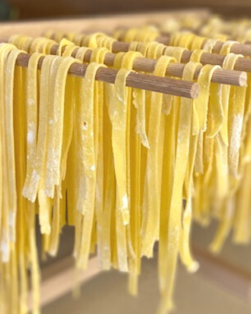 gluten free fettuccine pasta hanging on a drying rack