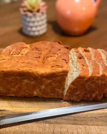 gluten free sandwich bread on a cutting board with a knife