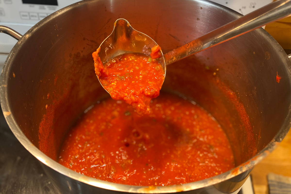 salsa in a pot with a ladle full