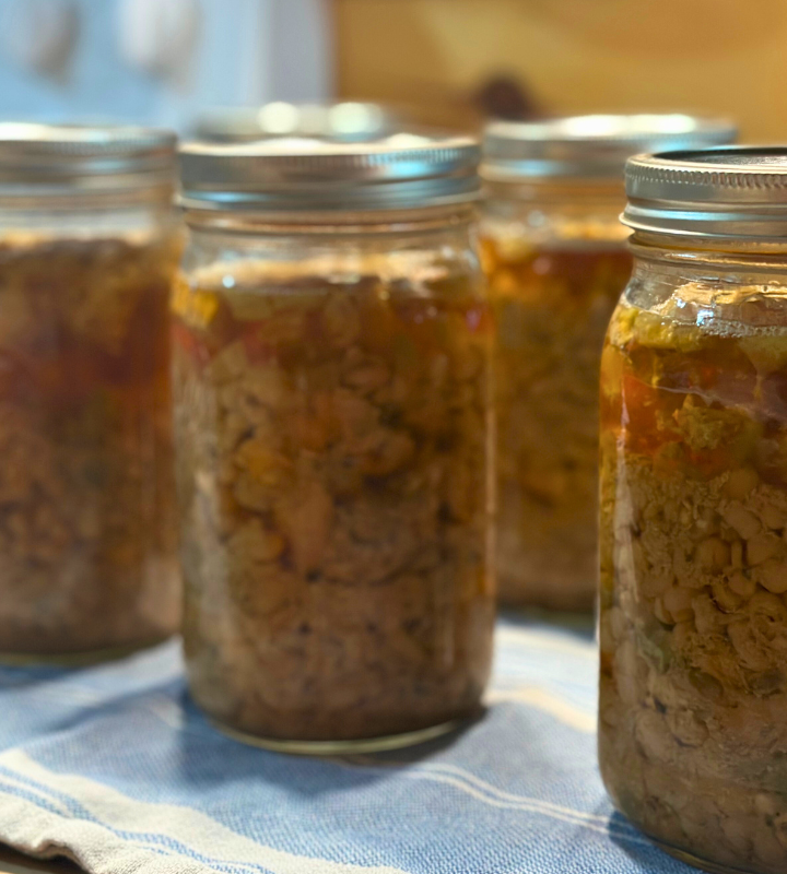 white chicken chili in quart jars on a blue towel