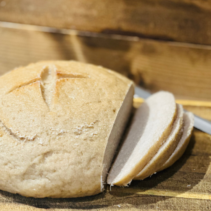 gluten free sourdough bread sliced on a wood cutting board with knife