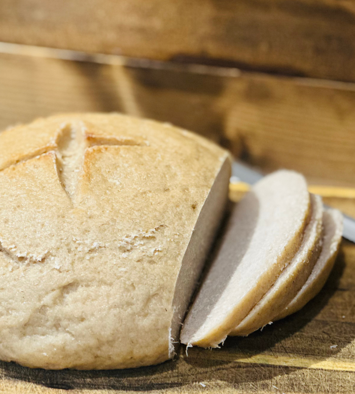 gluten free sourdough bread sliced on a wood cutting board with knife