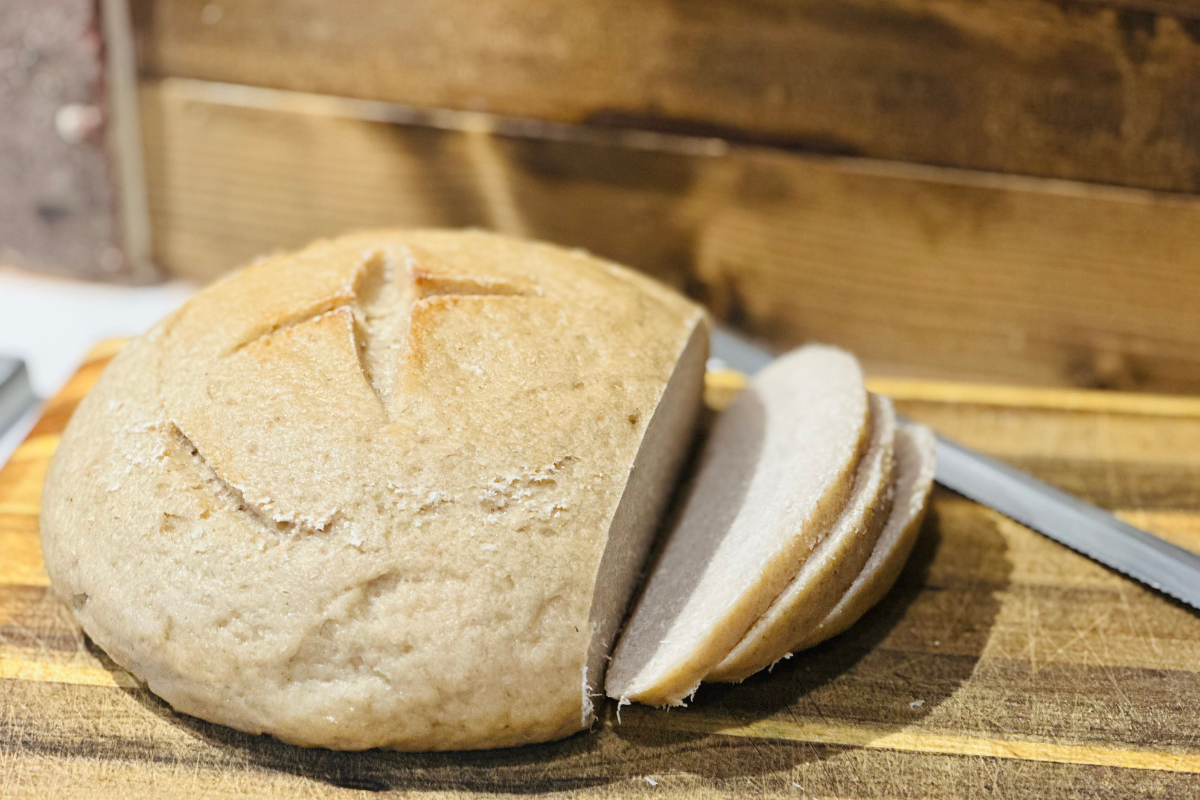 gluten free sourdough bread sliced on a wood cutting board with knife